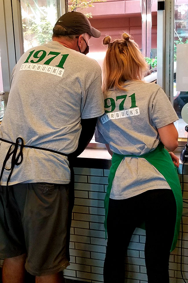 Larry and a fellow Starbucks partner proudly wearing Starbucks' 50th Birthday tees.